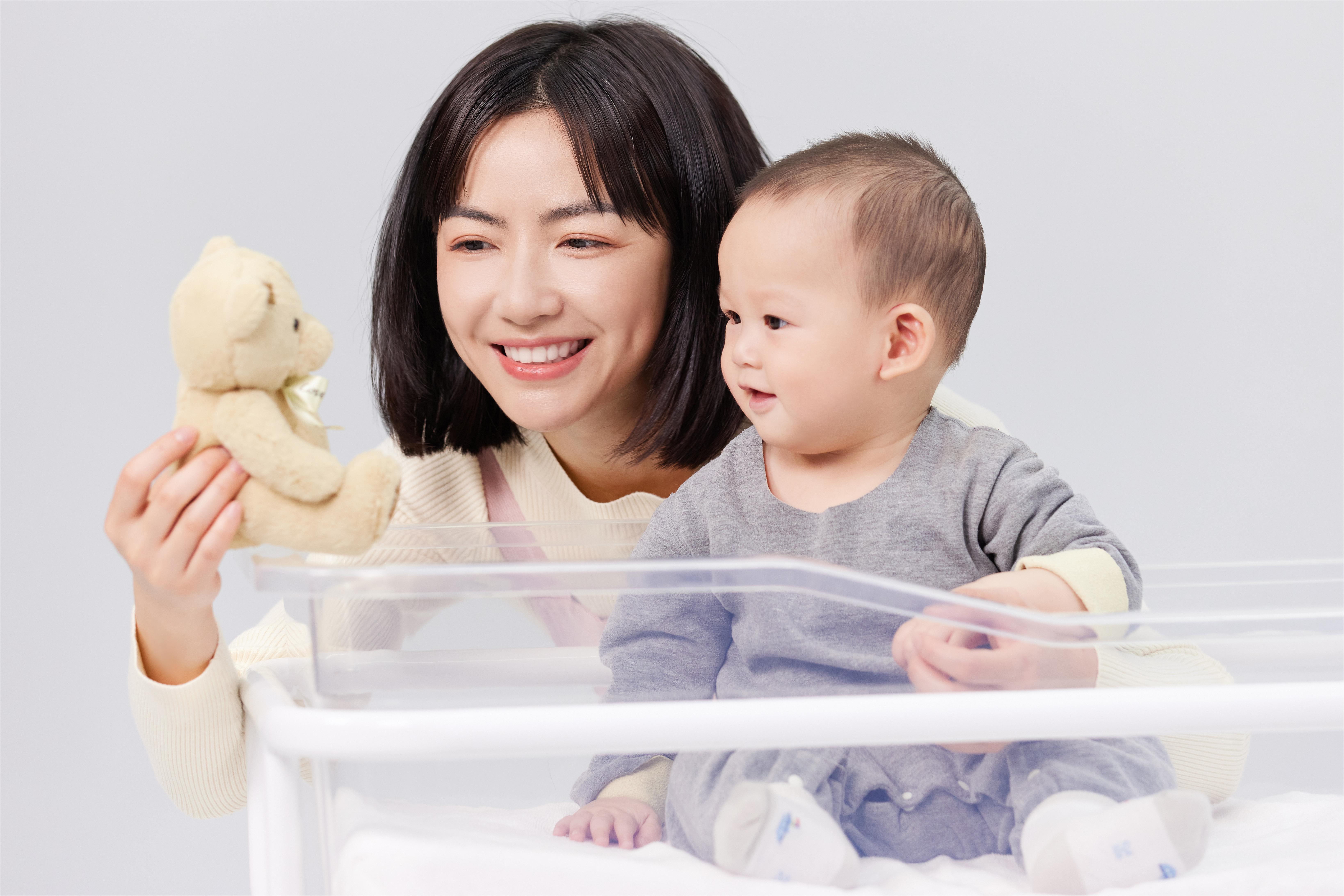 摄图网_501728685_月嫂年轻妈妈用毛绒玩具逗宝宝开心（企业商用）.jpg