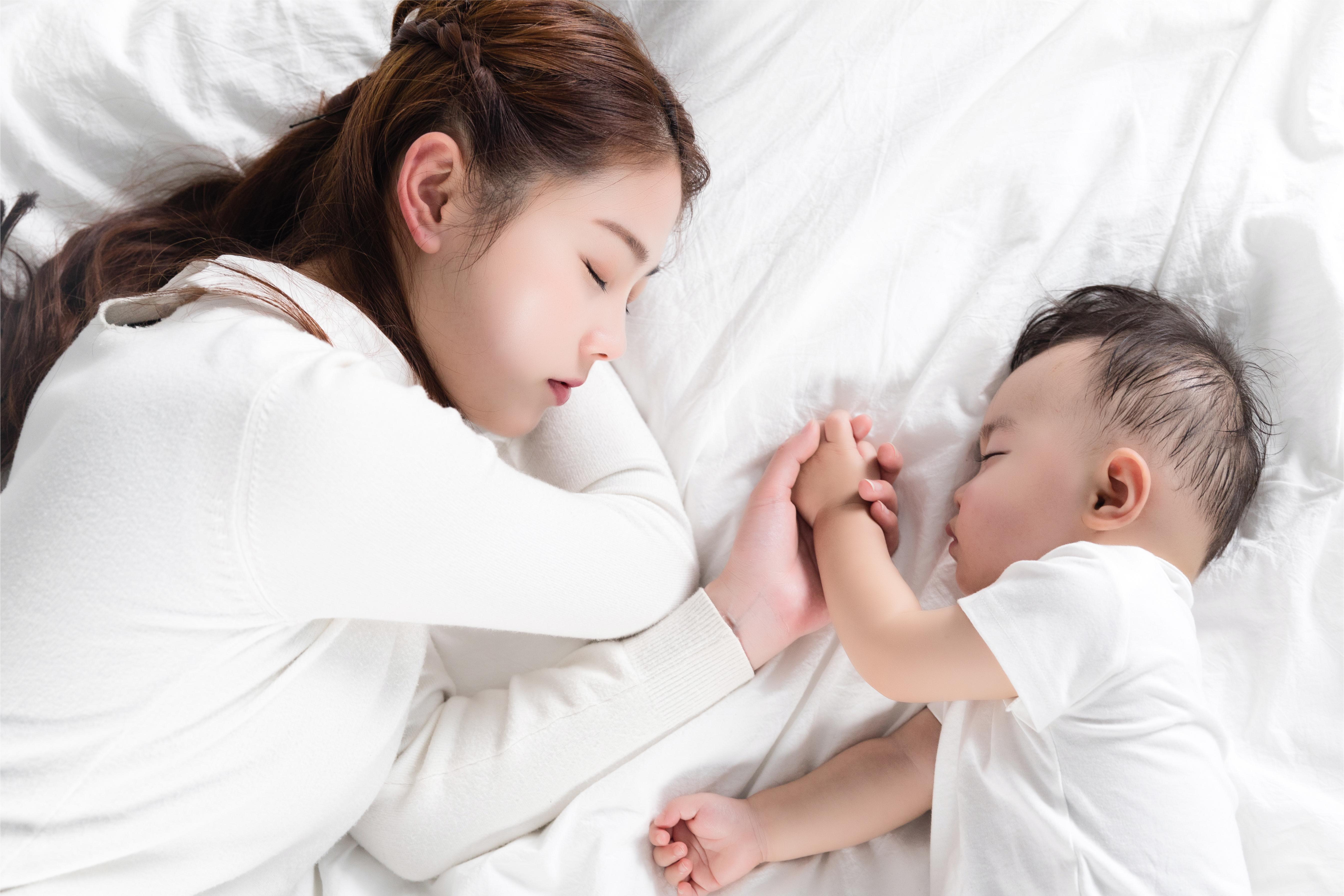 摄图网_501199505_妈妈牵着宝宝的手睡觉（企业商用）.jpg